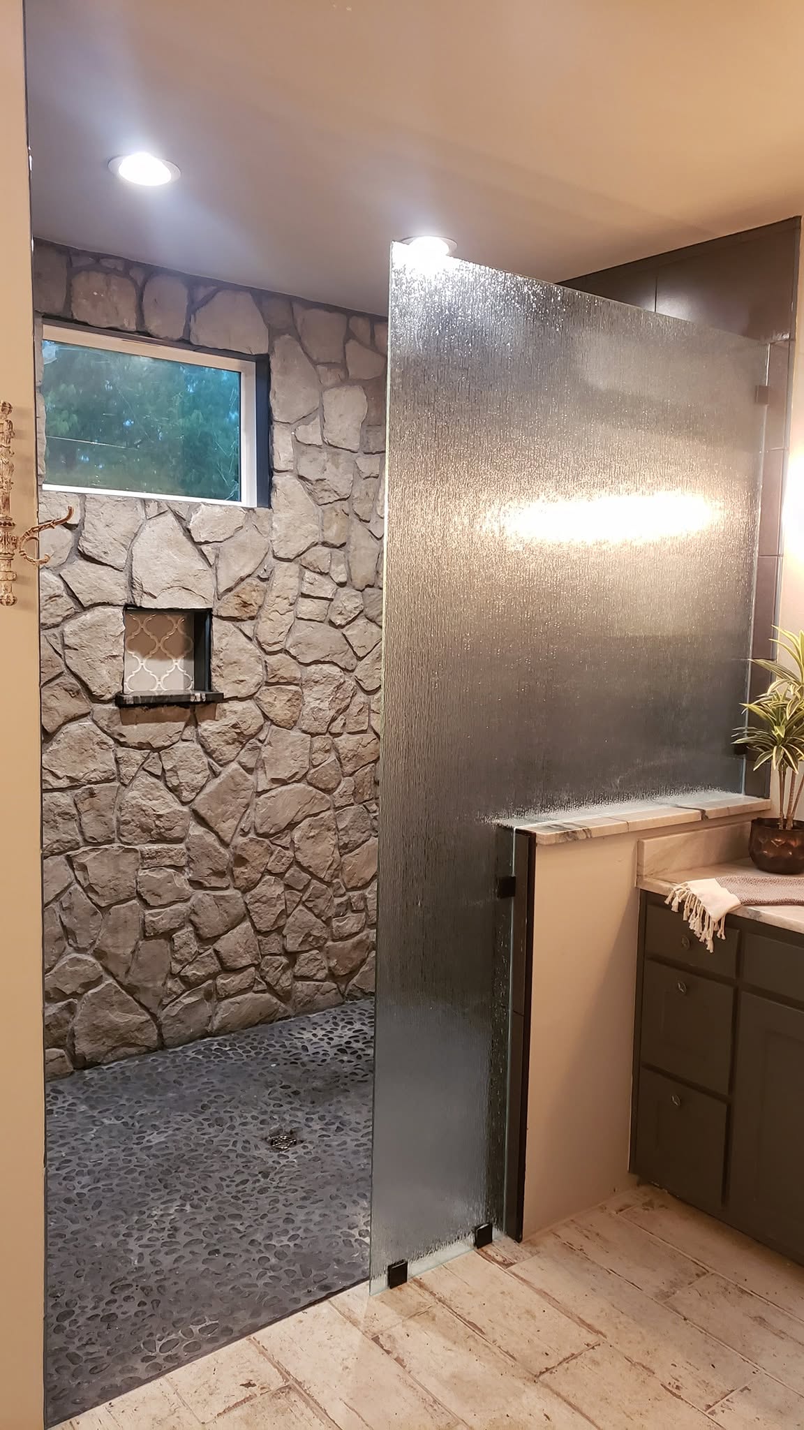 Textured privacy glass panel in stone shower